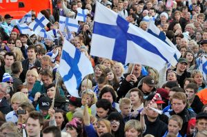 Paljon ihmisiä liehuttamassa Suomenlippuja