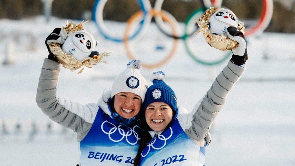 Kerttu Niskanen ja Krista Pärmäkoski tuulettavat palkintopallilla, taustalla olympiarenkaat