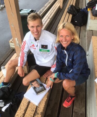 Topi Raitanen ja Tuuli Merikoski katsovat vierekkäin kameraan Eläintarhan urheilukentän katsomossa treenivaatteet päällä