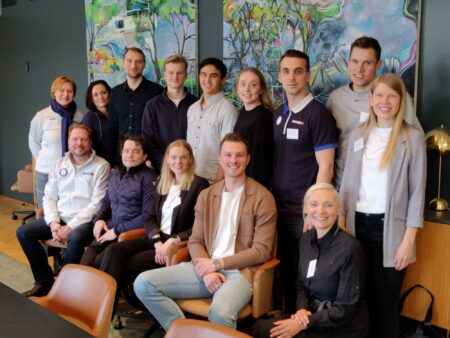 14 henkilöä ryhmäkuvassa katsoo kameraan