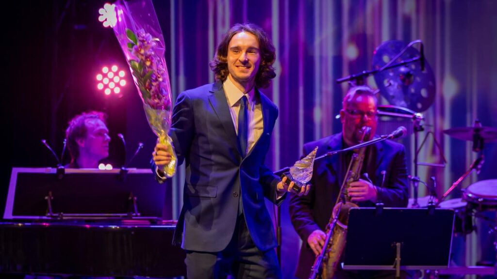 Riku Illukka kukkakimppu ja palkinto kädessä gaalassa