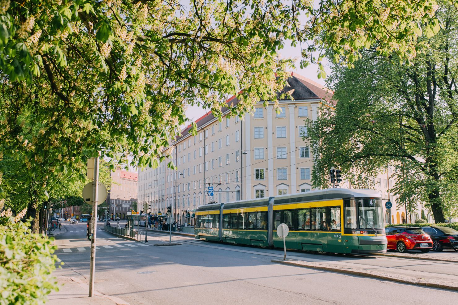 Helsinki street view with old buildings, trees and a tram